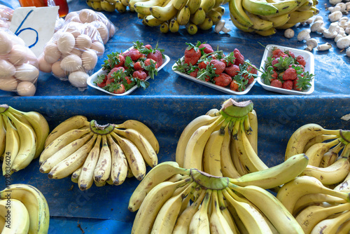 Fresh bananas, strawberries and organic eggs displayed at a local market stall