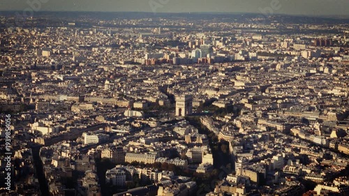 Evoking Parisian charm and nostalgia an aerial view of Paris with the Arc de Triomphe shot in a Super 8 film style The blurry handheld retro-film aesthetic adds a stylish and vintage feel to the citys