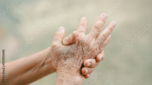Close up of elderly hands clasped in discomfort, showing joint stiffness and arthritis pain. Senior holding painful hand, representing aging health problems and chronic condition concept.