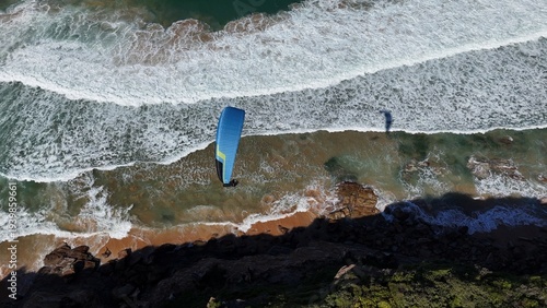 Bilde på lerret Paraglider flying over the beach near a headland in Sydney Australia