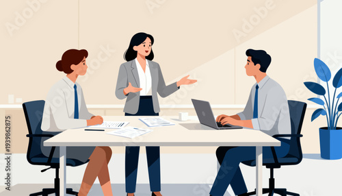 Three professionals discuss business plans around a white table. One woman stands, gesturing while speaking. Man sits, typing on a laptop. Another woman listens, notes in hand