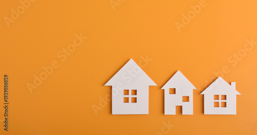 Fotografie Row of house icons on orange background with copy space