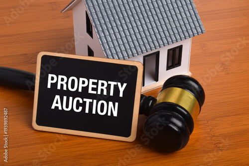 Property auction concept. Model house and judge gavel representing real estate bidding, foreclosure sales, legal property auctions, and investment opportunities in housing markets.