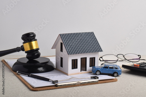 Judge gavel, house model, car, financial documents, and calculator. Concepts for property law, asset ownership, mortgage planning, and legal decisions affecting real estate and personal assets.