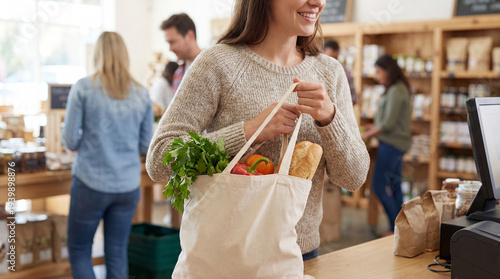 A customer shops, carrying a reusable shopping bag filled with fresh groceries in eco-conscious supermarket, capturing sustainable shopping habits.