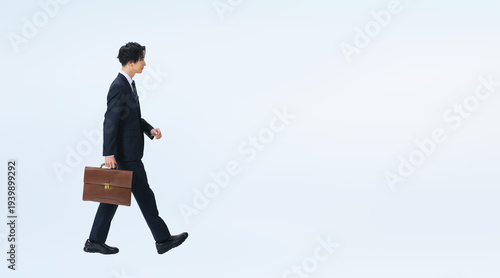 スーツを着て歩く男性ビジネスパーソンの全身写真