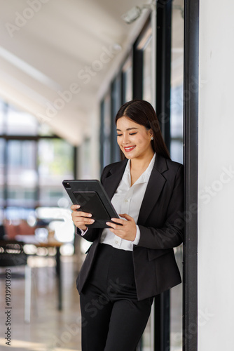 In a chic and inviting office, a professional woman engages with her tablet, embodying modern elegance and the evolution of digital communication in the workplace. Free Download In a chic and inviting office, a professional woman engages with her tablet, embodying modern elegance and the evolution of digital communication in the workplace. - GFXLoad