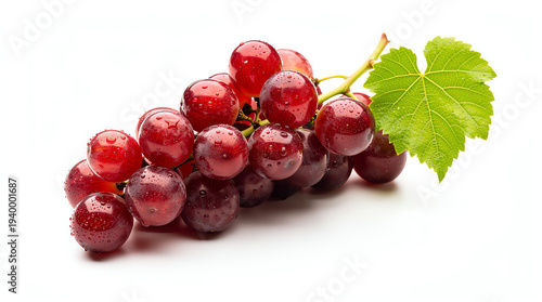 A fresh bunch of red grapes with water droplets and a green grapevine leaf on a white background, highlighting their juicy and ripe appearance