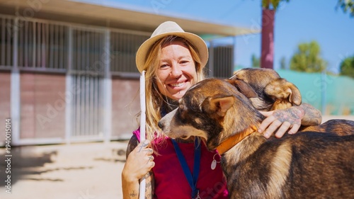 Принти на полотні Woman volunteering at animal shelter hugging dogs