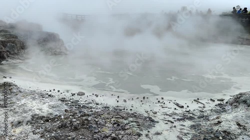 High angle view of Sikidang Crater Dieng with misty sulfur fumes and rocky terrain.