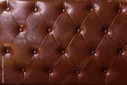 Brown tufted leather texture background with buttons.