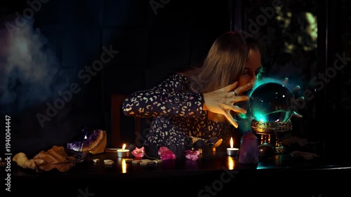 Intense fortune telling ritual with a woman psychic interacting with a crystal ball candles smoke amethyst and runes in a dark mystical esoteric atmosphere