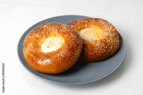 Fresh bread rolls filled with cheese on a blue plate in a kitchen setting during daytime