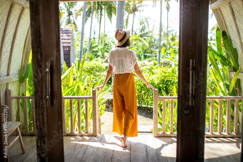 Woman enjoying tropical vacation view from wooden balcony