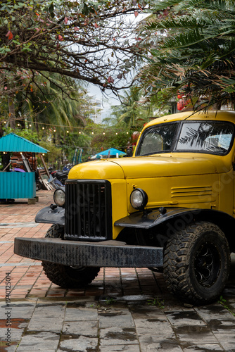 Vintage Yellow Truck Parked in a Tropical Outdoor Setting