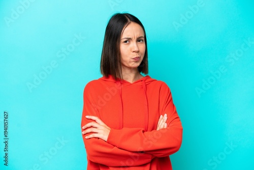 Young caucasian woman isolated on blue background feeling upset