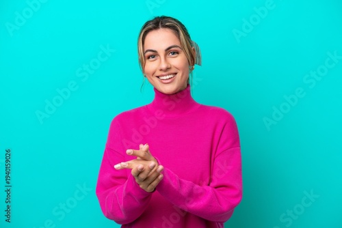 Young caucasian woman isolated on blue background applauding after presentation in a conference