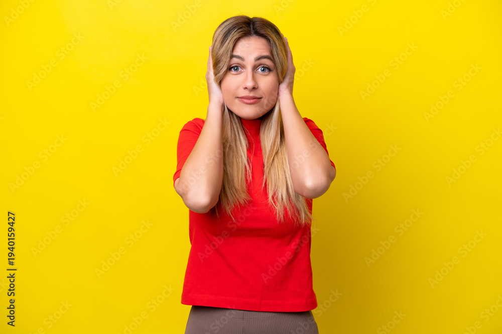Fototapeta premium Young Uruguayan woman isolated on yellow background frustrated and covering ears