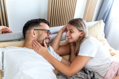 фотографія Happy young couple lying in bed and sharing a romantic moment