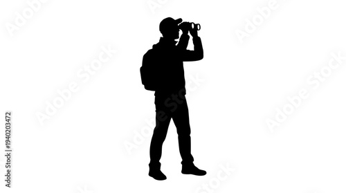 Man in silhouette looking through binoculars with backpack on