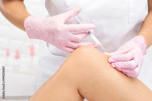 A doctor of aesthetic cosmetology makes lipolytic injections to burn body fat on a woman’s on the hips, legs and thighs . Female aesthetic cosmetology in a beauty salon.