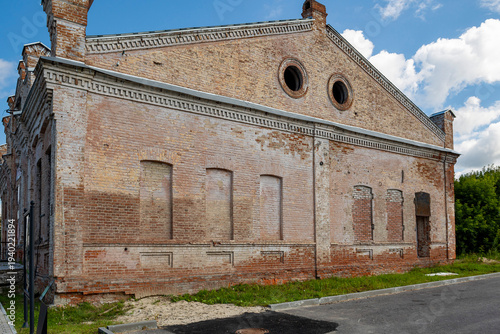 The weathered facade of an old building, with its brickwork and window openings still intact, is a sunny autumn day.