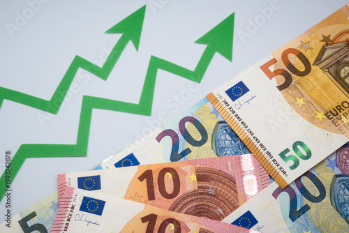 Increase in the average value of the Euro exchange rate. Euro money and green graph arrows.

