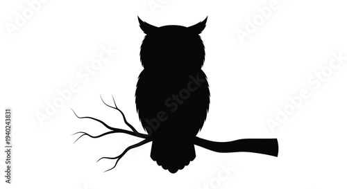 A striking black owl perched on a branch distinct silhouette