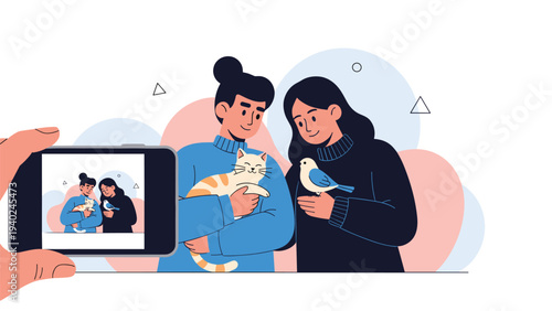 Hand holding a smartphone taking a photograph of two women holding a cat and a bird in a warm friendly indoor setting.