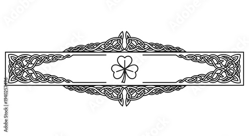 An ornate black and white illustration featuring a central flower motif within an intricate border design.