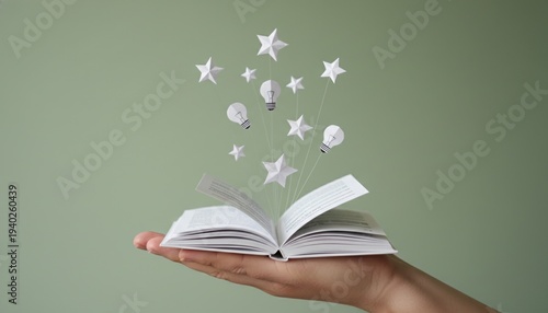 Wallpaper Mural book, idea, creativity, star, inspiration, knowledge, imagination emerging from an open book held in hand on green background, conceptual image of education, wisdom and dreaming. Torontodigital.ca