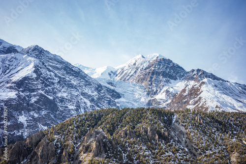 Quadro em tela Majestic snow-covered peaks of the Annapurna mountain range rise above rugged cliffs and alpine forests in the Himalayas of Nepal