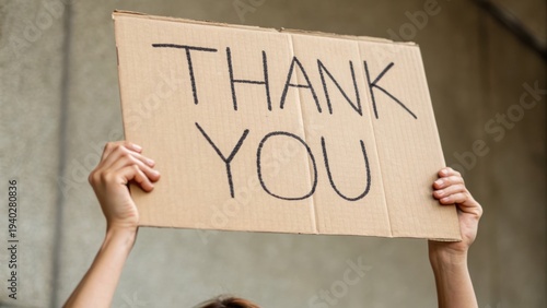 Person holding up a cardboard sign with 