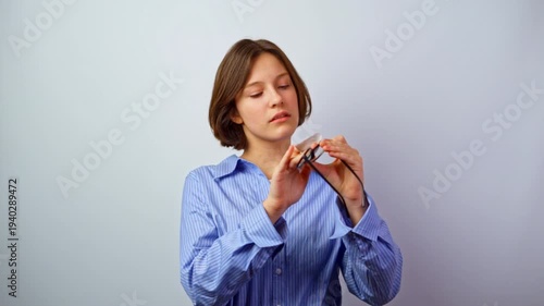 Beautiful girl caring for glasses for vision wiping them clean young woman cleaning eyeglasses maintenance hygiene lens care careful routine studio portrait
