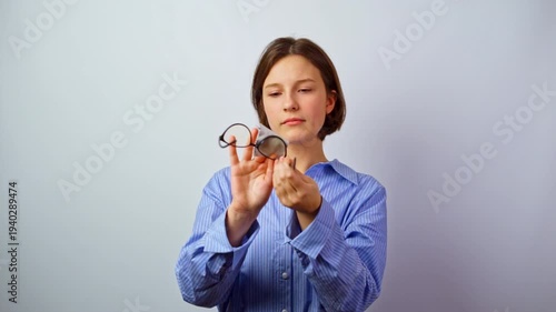 Pretty girl caring for glasses for vision eyeglass care young woman cleaning spectacles maintenance lens hygiene daily routine studio portrait optics