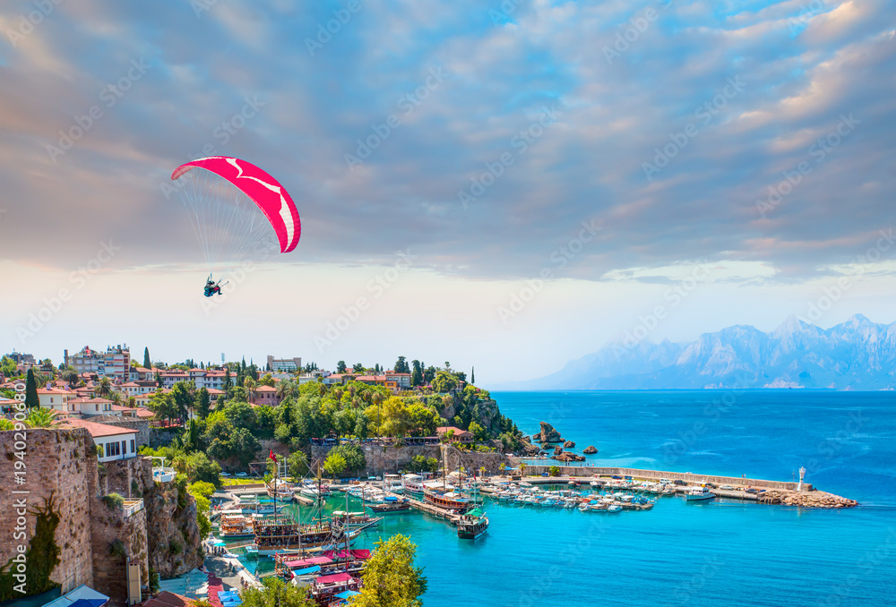 Obraz premium Happy people parasailing on Old town of Antalya Beach in summer - Aerial view of Antalya old town or harbour (Kaleici), Bay with ships and boats in summer - Antalya, Turkey 