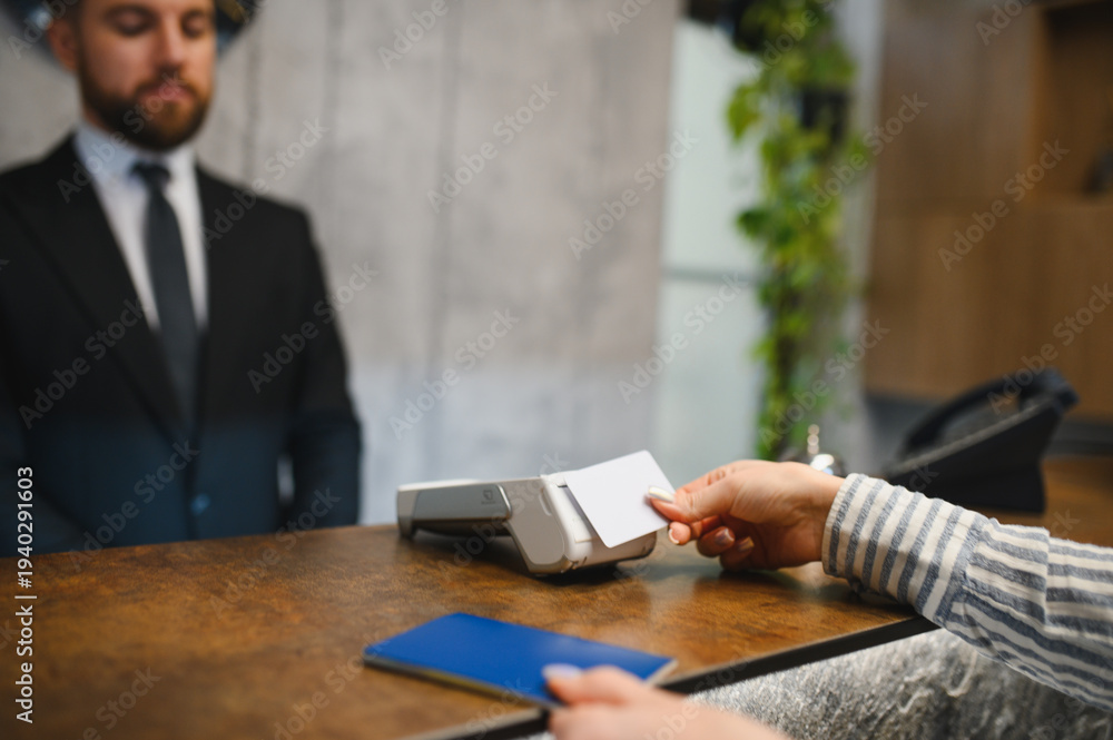 Fototapeta premium Person making a contactless payment at hotel reception