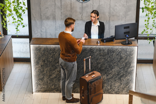 Traveler checking in at modern hotel reception desk