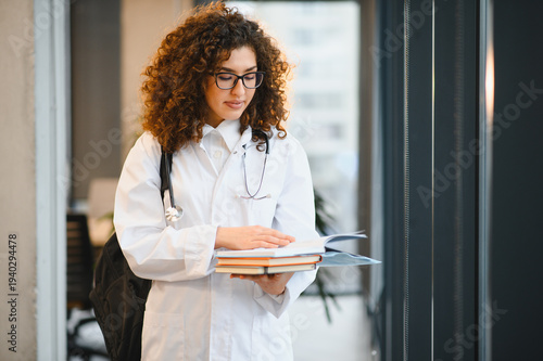 Medical student reading books holding stethoscope