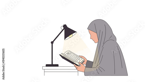 A woman in hijab reading a book under a desk lamp on a table indoors