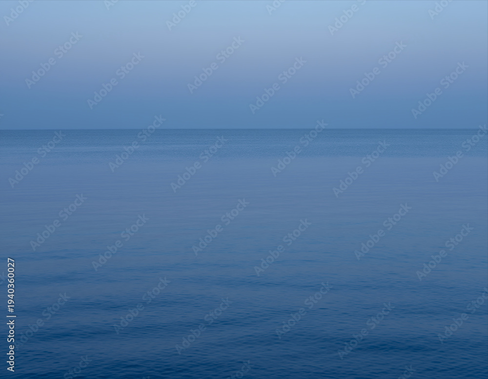 Obraz premium Serene Calm Ocean Horizon at Dusk with Smooth Water Surface and Soft Gradient Sky Perfect for Meditation Backgrounds or Tranquil Digital Design Projects