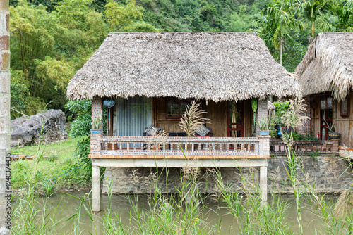 Traditional stilt house with a natural thatched roof standing over water in vietnam