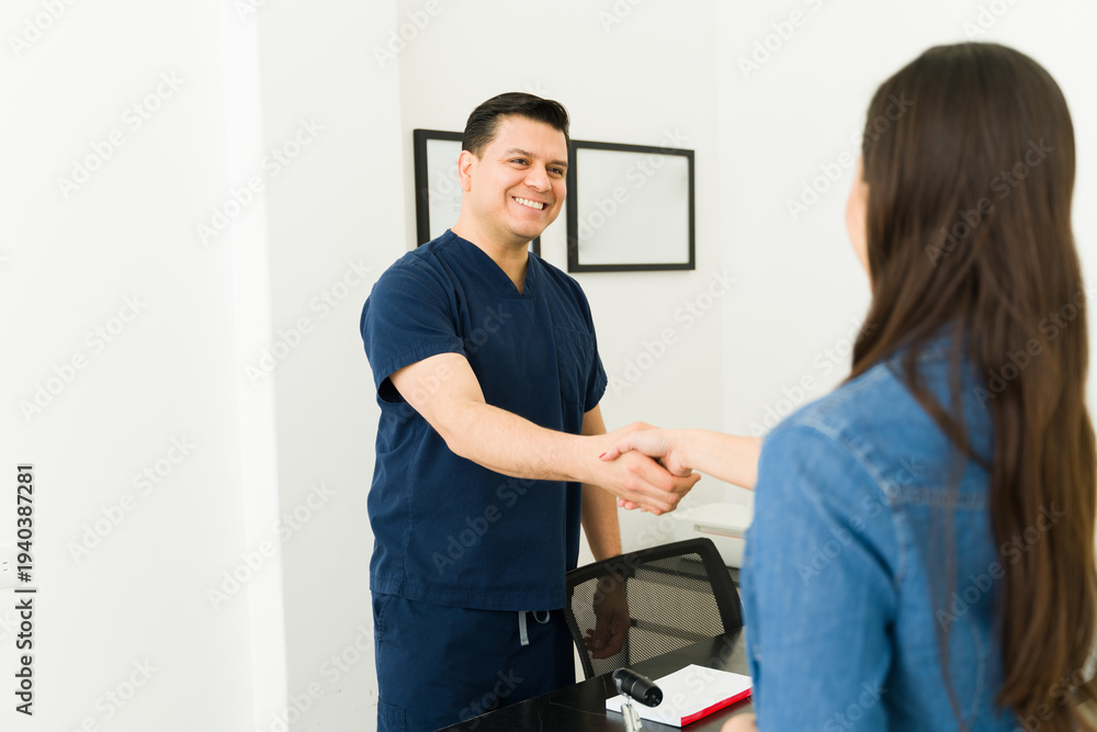 Obraz premium Doctor and patient shaking hands at medical clinic, starting a consultation about healthcare services
