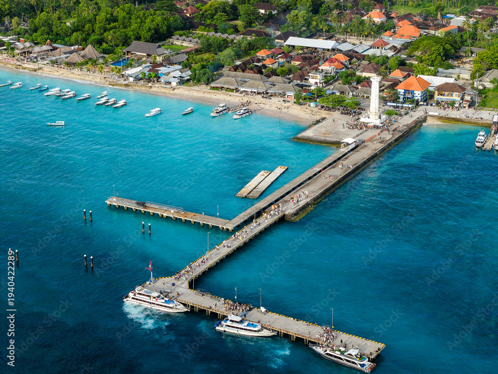 Fototapeta premium Passengers walking along the bustling pier at Nusa Penida port over clear blue water