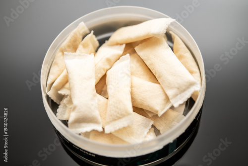 Fotografija Closeup of Nicotine Pouches in Open Container on Black Surface