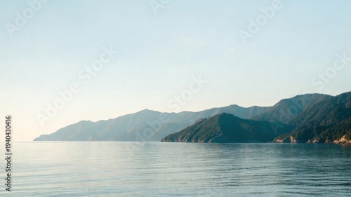 Serene coastal landscape with mountainous horizon and calm waters.