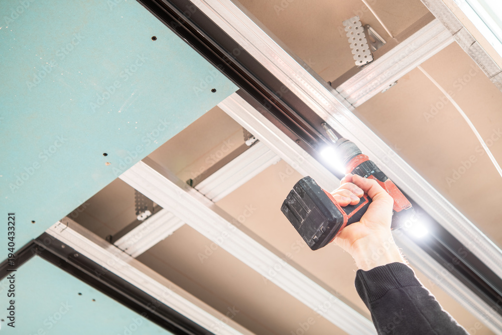 Fototapeta premium Installation of Suspended Ceiling with Track Lighting and LED Lights