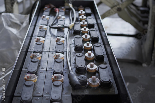 A stack of black locomotive batteries with yellow caps. Lead Acid Battery Box for Forklift at Cargo Pallet.