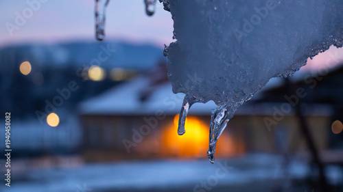 Obraz na płótnie Melting Icicle at Dusk with Warm City Lights