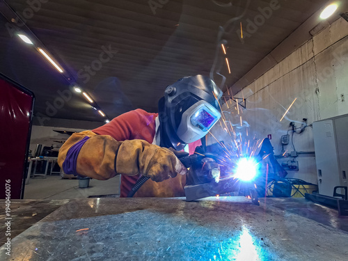 Close-up of Skilled Welder Using MIG-MAG Torch on Metal Structure in Industrial Factory